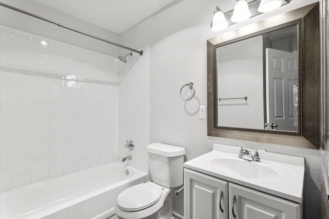 Private bath in front bedroom with large mirror, vanity, and shower / bath combination | Image 24