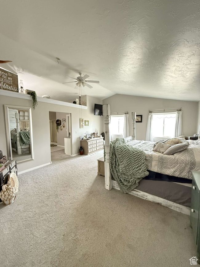 Carpeted bedroom with ceiling fan, vaulted ceiling, and a textured ceiling | Image 31