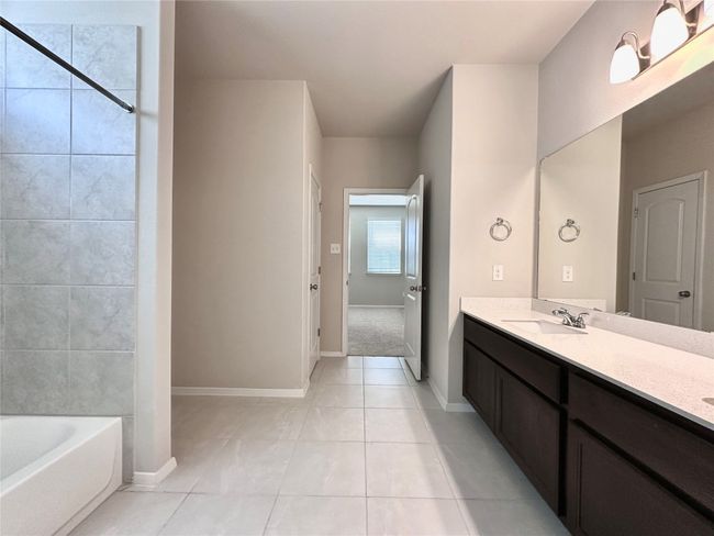 Bathroom with vanity, a tub to relax in, tile patterned flooring, and a shower | Image 16