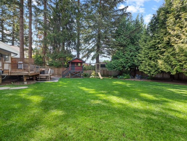 View of yard featuring a playground and a wooden deck | Image 34