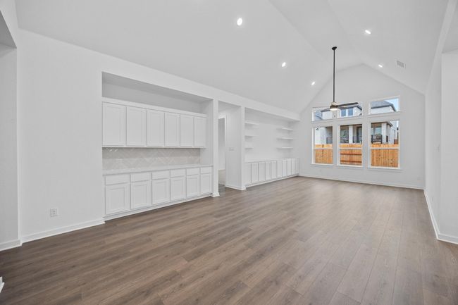 Unfurnished living room with dark wood-type flooring, recessed lighting, high vaulted ceiling, and ceiling fan | Image 19