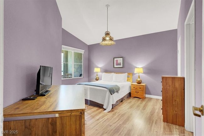 Bedroom with baseboards, light wood-type flooring, and lofted ceiling | Image 19