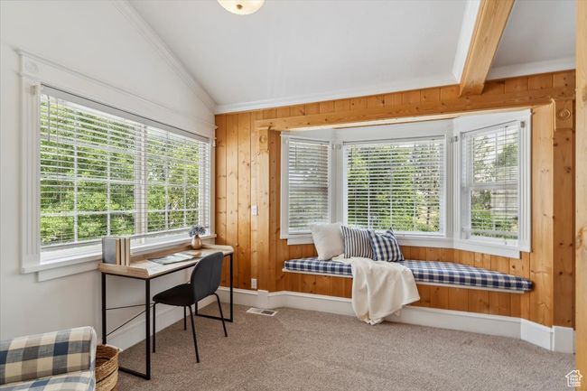 Carpeted sitting area used as office with wooden walls, healthy amount of natural light, lofted ceiling, ornamental molding, and baseboards | Image 14