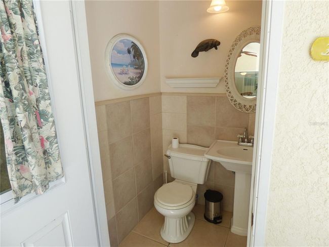 the pool bath is floor and walls tiled, upgraded vanity and toilet, high ceiling | Image 34