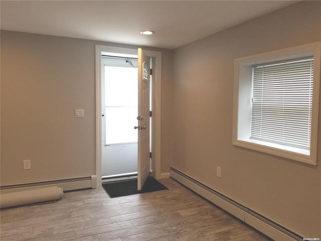 Doorway to outside with a baseboard radiator, light wood finished floors, recessed lighting, and baseboards | Image 6