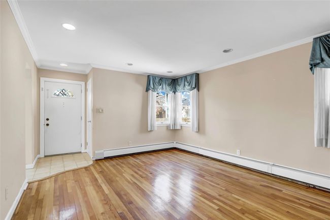 Foyer featuring a baseboard heating unit, baseboards, ornamental molding, recessed lighting, and wood-type flooring | Image 5