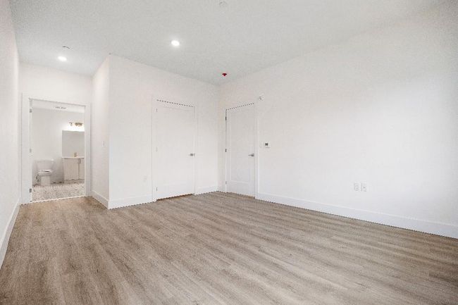 Unfurnished bedroom with light wood finished floors, recessed lighting, baseboards, ensuite bathroom, and a closet | Image 21
