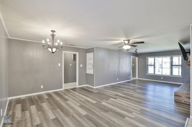 Unfurnished room featuring hardwood / wood-style floors, ceiling fan with notable chandelier, and crown molding | Image 6