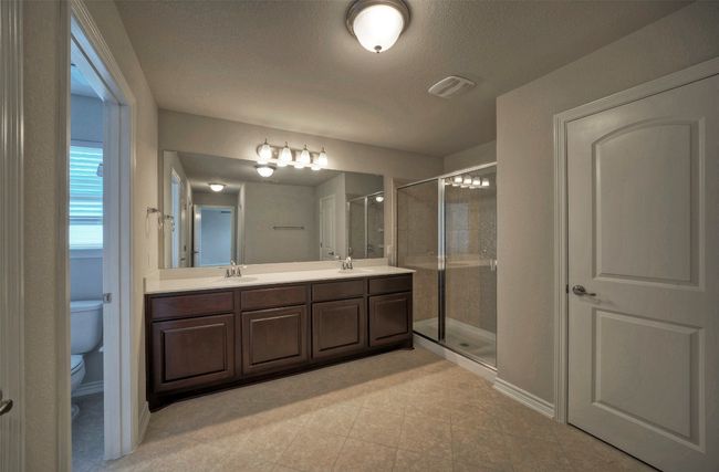 Bathroom with double vanity, a sink, toilet, and a shower stall | Image 19