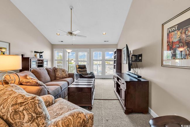 Living area featuring baseboards, recessed lighting, light colored carpet, a ceiling fan, and high vaulted ceiling | Image 9