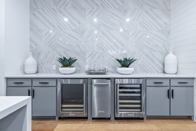 Indoor bar featuring wine cooler, backsplash, and light wood-type flooring | Image 14
