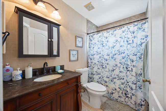 Bathroom featuring tile patterned floors, vanity, toilet, and a shower with shower curtain | Image 21