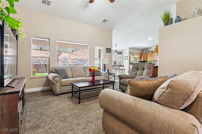 Living room featuring plenty of natural light, a ceiling fan, carpet, and baseboards | Image 12