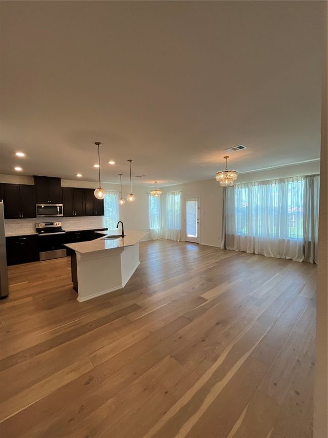 Kitchen featuring a chandelier, stove, recessed lighting, refrigerator, and visible vents | Image 9