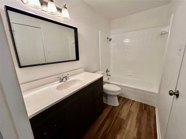 Full bath featuring wood finished floors, vanity, toilet, and shower / tub combination | Image 15