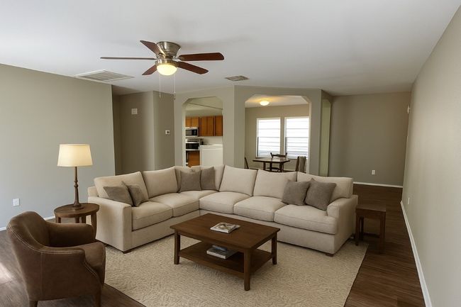 Living room with arched walkways, light wood-style floors, and a ceiling fan | Image 8