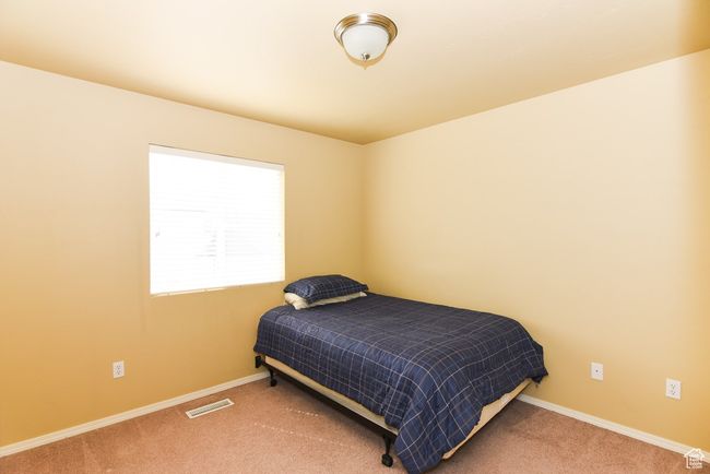 Bedroom featuring baseboards, carpet floors, and visible vents | Image 23