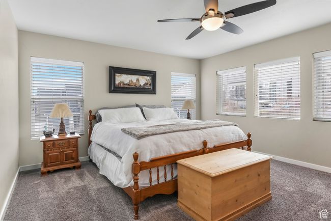 Bedroom featuring baseboards, ceiling fan, and dark colored carpet | Image 13