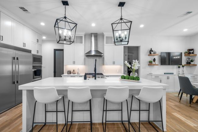 Kitchen with wall chimney range hood, a chandelier, built in appliances, open shelves, and recessed lighting | Image 11