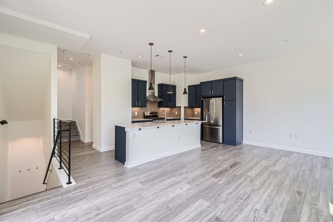 The open main floor layout is flooded with natural light from large windows, creating an inviting and airy ambiance. | Image 14