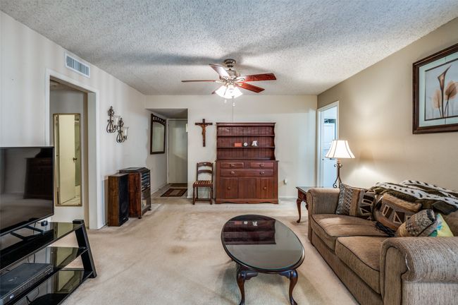 Carpeted living area with a textured ceiling and a ceiling fan | Image 4