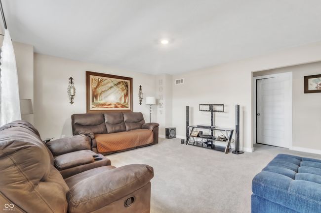living area featuring visible vents, baseboards, and carpet | Image 16