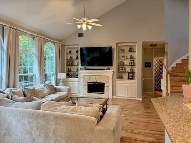 Living area featuring visible vents, stairs, built in features, ceiling fan, and light wood-type flooring | Image 13