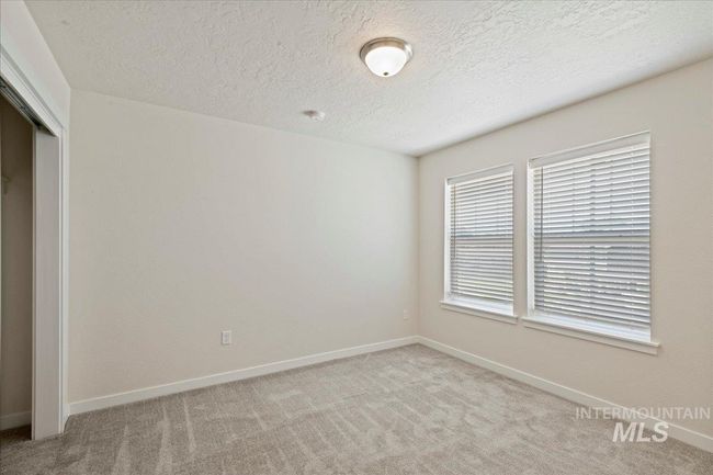 Unfurnished bedroom with a closet, light carpet, and a textured ceiling | Image 11