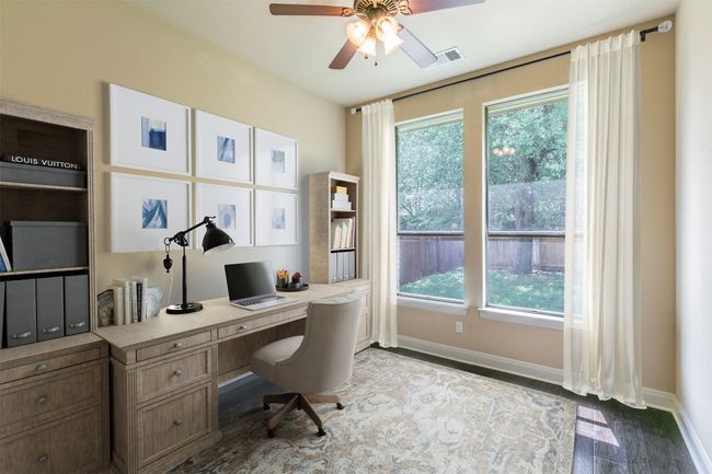 First floor home office featuring visible vents, a ceiling fan, baseboards, and wood finished floors | Image 22