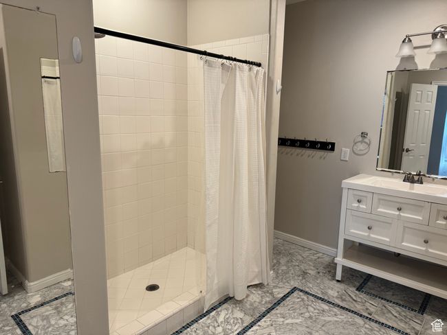 Full bath featuring a stall shower, vanity, and baseboards | Image 25