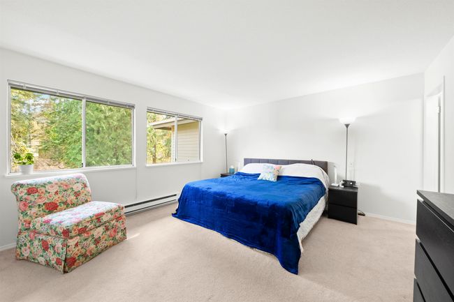 Bedroom with baseboard heating, light carpet, and baseboards | Image 18