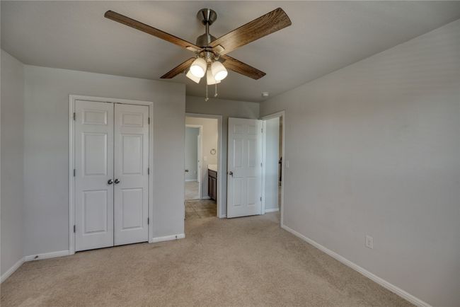 Unfurnished bedroom with baseboards, light carpet, a closet, and ceiling fan | Image 27