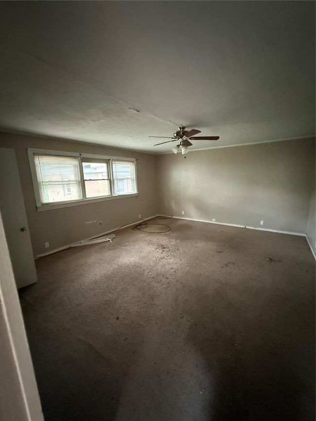 Carpeted empty room featuring ceiling fan and baseboards | Image 7
