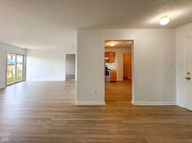 spare room with baseboards, wood finished floors, and a textured ceiling | Image 17