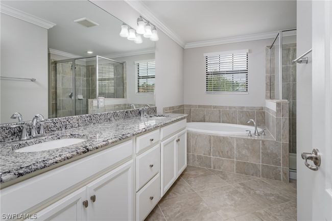 Bathroom with independent shower and bath, dual sinks, tile floors, and large vanity | Image 25