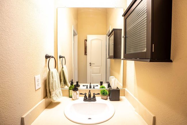 Bathroom with a textured wall and vanity | Image 19