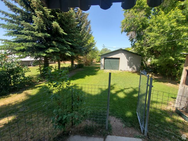 View of yard with a garage, an outdoor structure, and a gate | Image 15