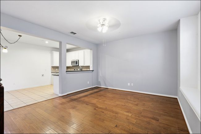 Unfurnished living room featuring wood-type flooring, ceiling fan, visible vents, and baseboards | Image 5