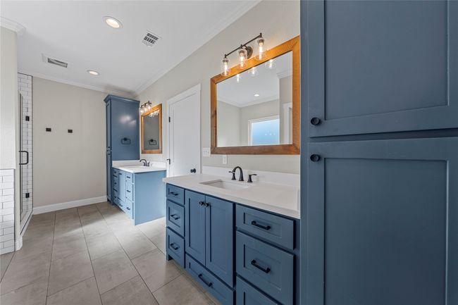 Bathroom with a sink, visible vents, and crown molding | Image 24