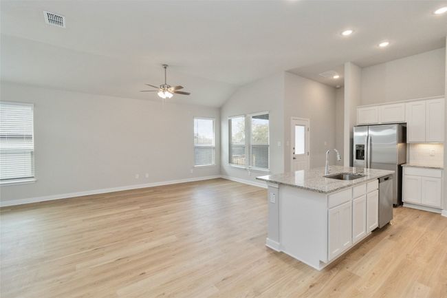 Kitchen with visible vents, light wood-style flooring, appliances with stainless steel finishes, a kitchen island with sink, and a sink | Image 8