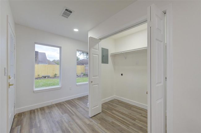 Conveniently located off the kitchen, the laundry room is both practical and efficient. It offers ample cabinet storage to keep cleaning supplies and household items organized. The space is designed for ease of use, with plenty of room for laundry tasks and folding. | Image 15