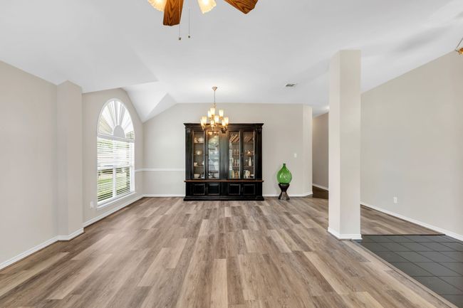 Dining area featuring vaulted ceiling, wood finished floors, and ceiling fan with chandelier | Image 8