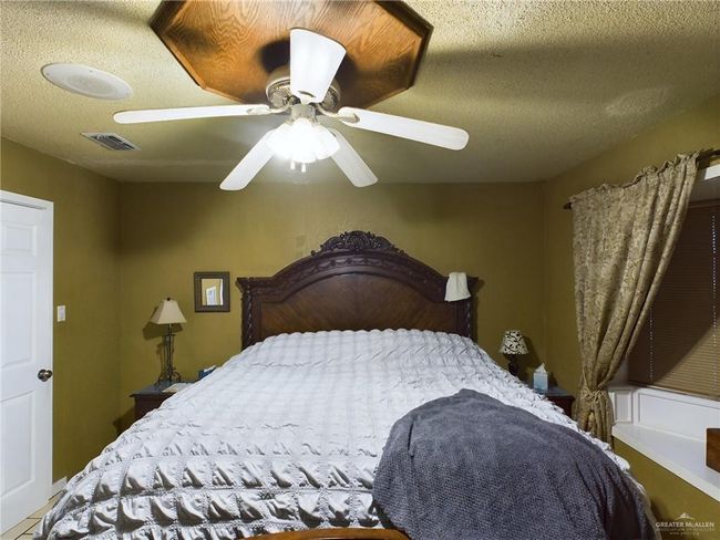 Bedroom featuring a textured ceiling and ceiling fan | Image 9