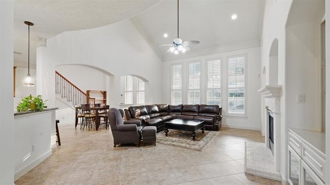Gorgeous 2 story living room with stone cast fireplace and expansive windows. As with all the rooms, plantation shutters are on all of the windows. | Image 11