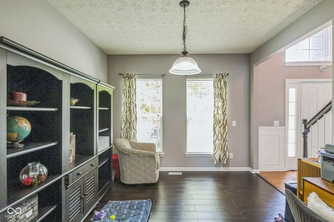 living area featuring dark wood-type flooring, plenty of natural light, and a textured ceiling | Image 9