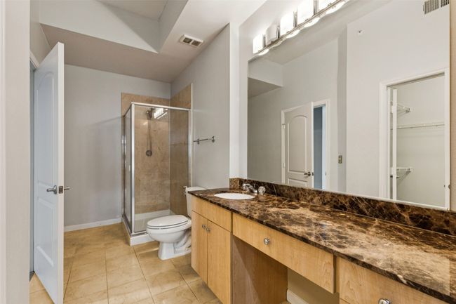 Full bath with a shower stall, vanity, a spacious closet, and tile patterned flooring | Image 16