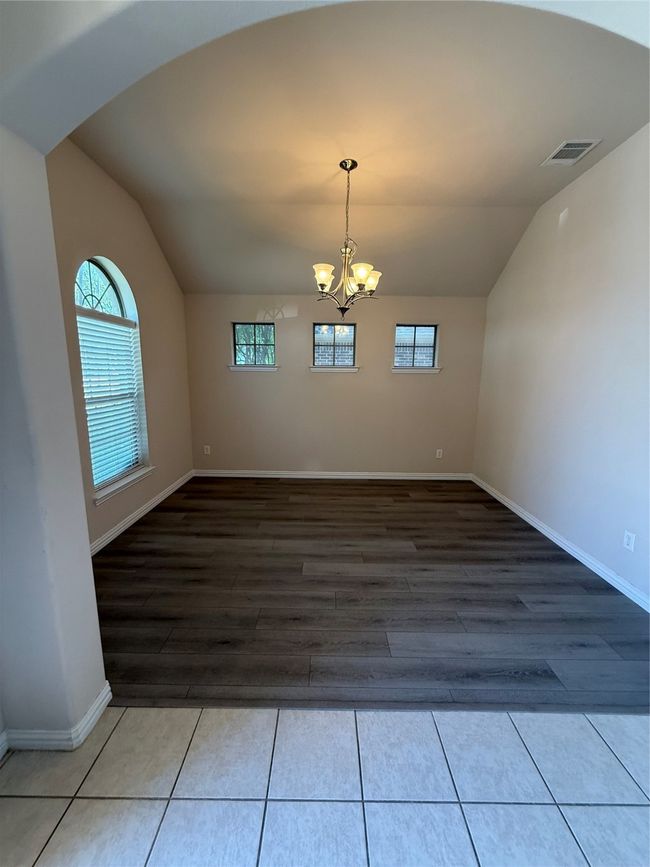Unfurnished dining area with visible vents, a wealth of natural light, a chandelier, and lofted ceiling | Image 5