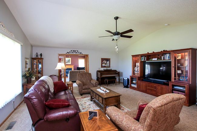 Step into the spacious living room featuring a vaulted ceiling. | Image 4
