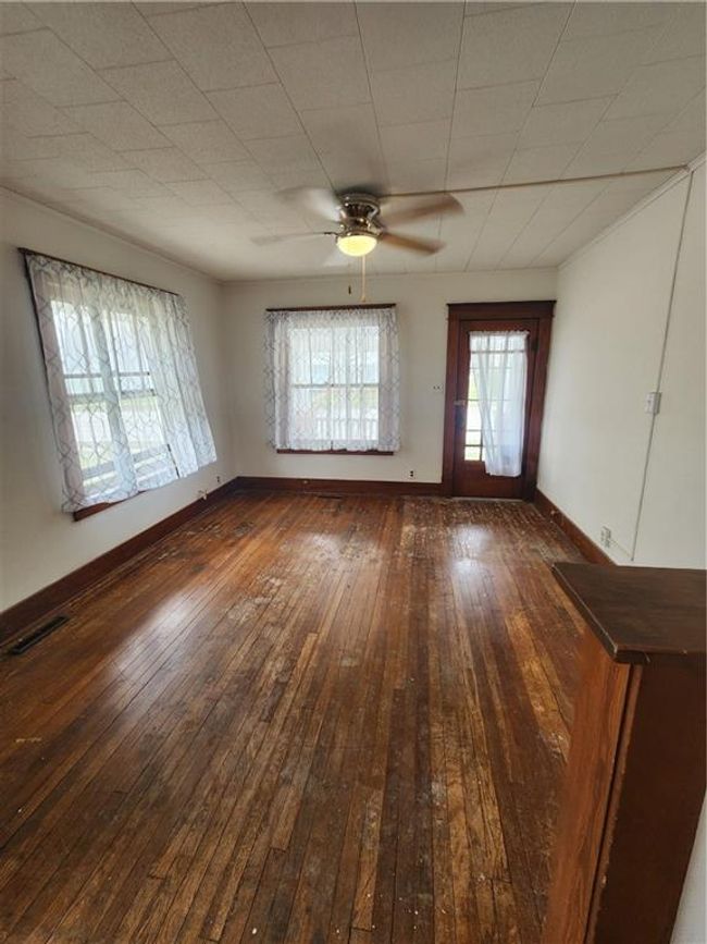 Empty room featuring a ceiling fan, dark wood-style flooring, baseboards, and visible vents | Image 10