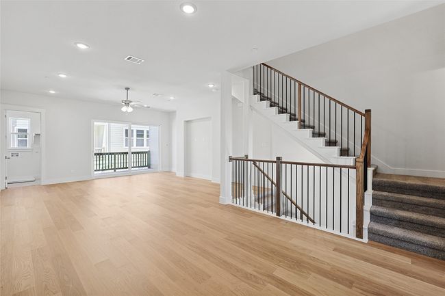 Unfurnished living room with ceiling fan, baseboard heating, and light wood-type flooring | Image 12